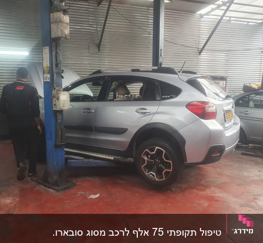 רכב על ליפט במוסך עם מכונאים